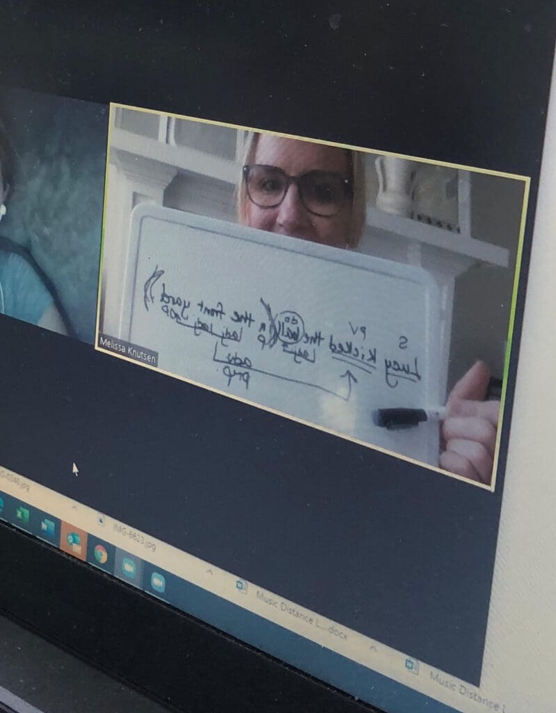 Teacher holding white board of diagramed sentences